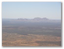 Am Horizont sieht man die Olgas, eine Felsformation 50 km von Ayers Rock entfernt.