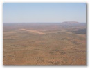 Jetz sieht man ihn, den Ayers Rock. Modern erschlossen mit dazugehoeriger Landepiste.